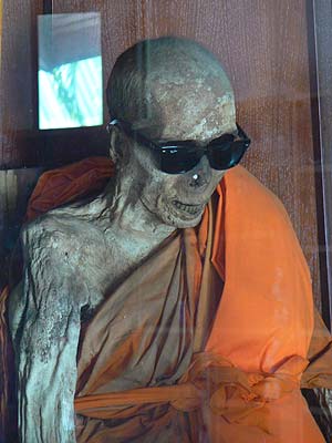 Loung Por Daeng, очки защищают его от вспышек фотоаппаратов, а саркофаг от шума и мирской суеты.